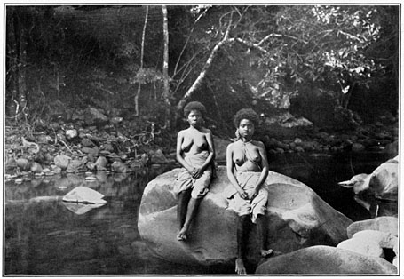 Negrito women of Bataan on a rock in a stream.
